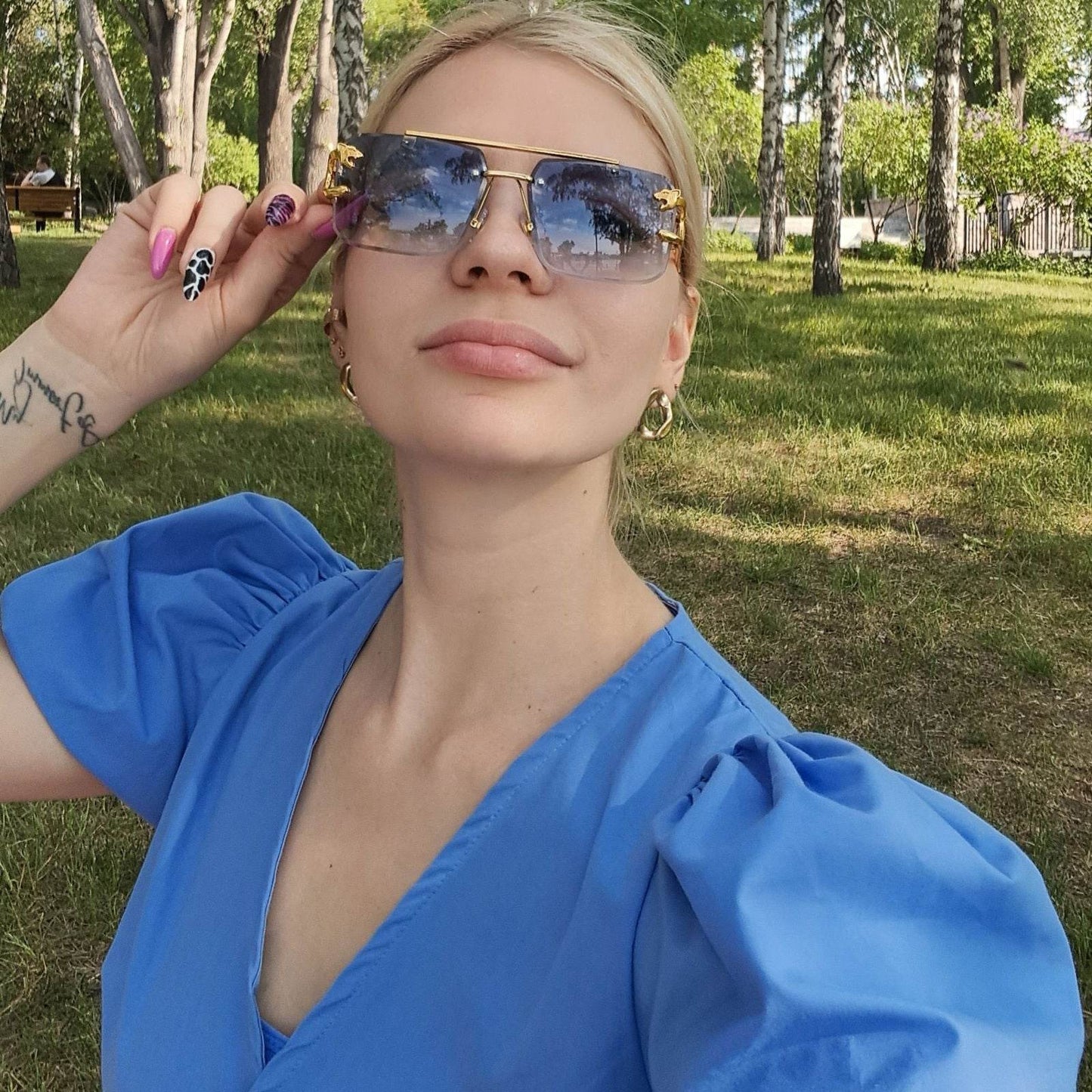 Sunglass Lover retro rimless sunglasses for men shown on model outdoors in a park selfie wearing a blue dress
