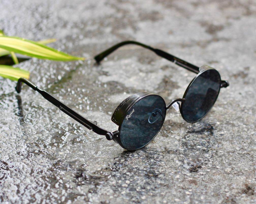 Sunglass Lover steampunk round sunglasses for men black metal frame dark tinted lenses on textured stone