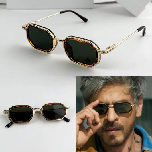 Sunglasses with gold frame and dark lenses, displayed on a white background.