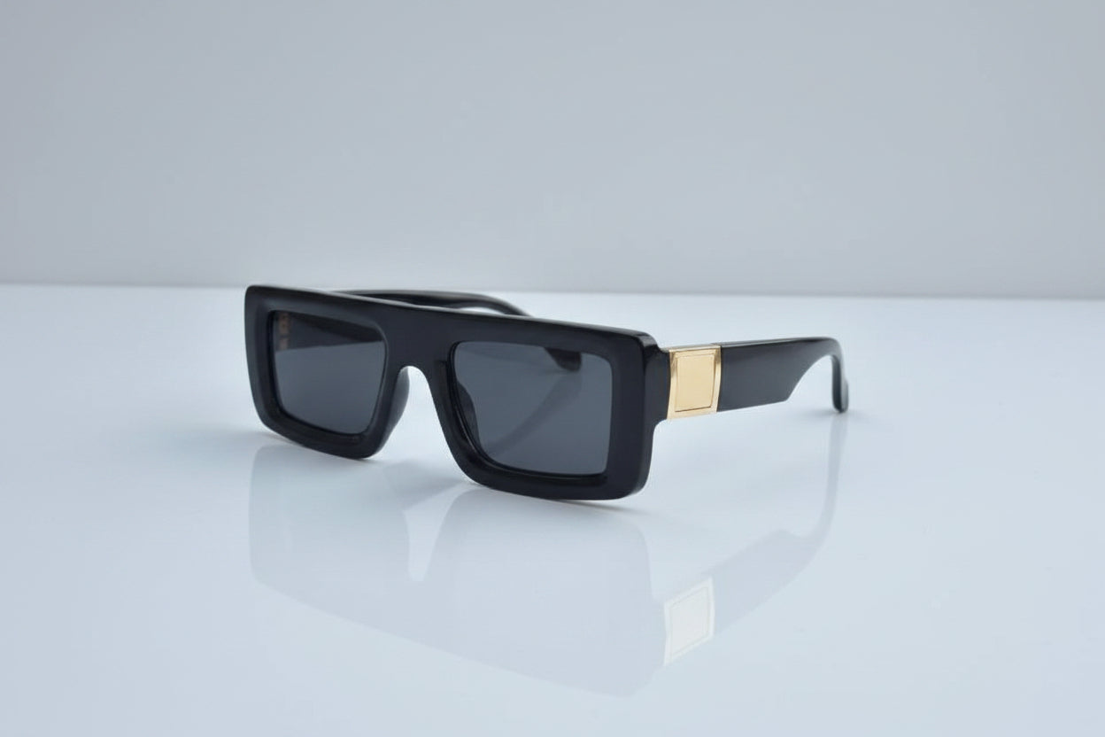 Black sunglasses with gold accents on a white surface, accompanied by Off-White packaging.
