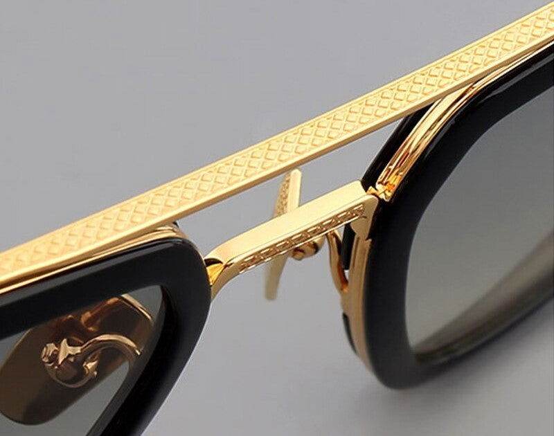 Sunglass Lover close up of gradient double bridge square sunglasses with gold textured bridge and black frames