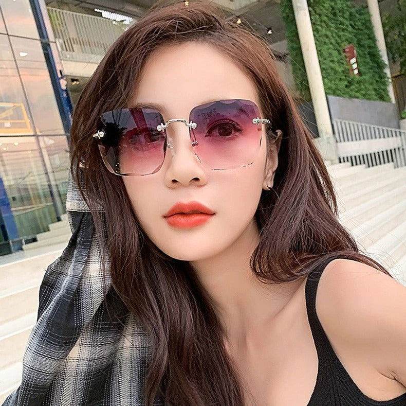 Sunglass Lover model wearing rimless oversize square sunglasses with pink gradient lenses and silver temples