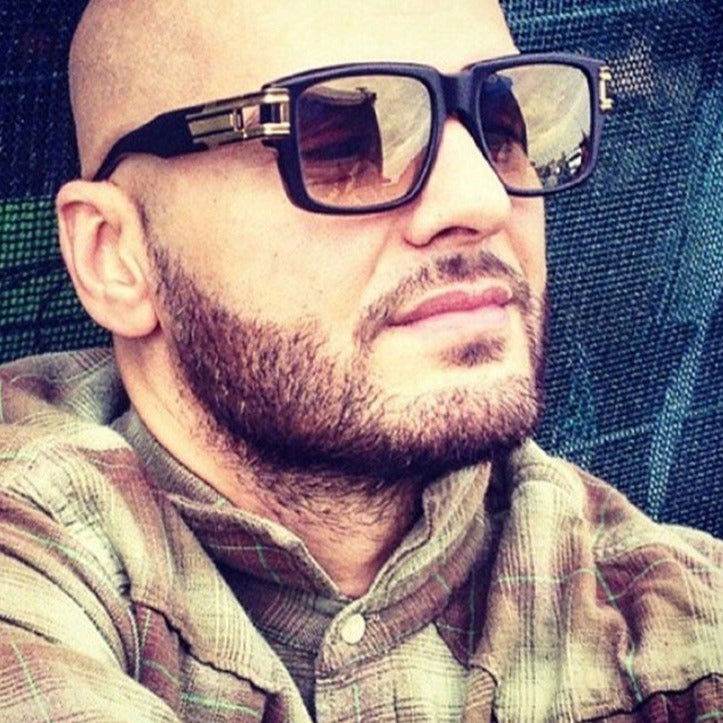 Bearded man wearing Sunglass Lover vintage thick square sunglasses with black frames and amber lenses