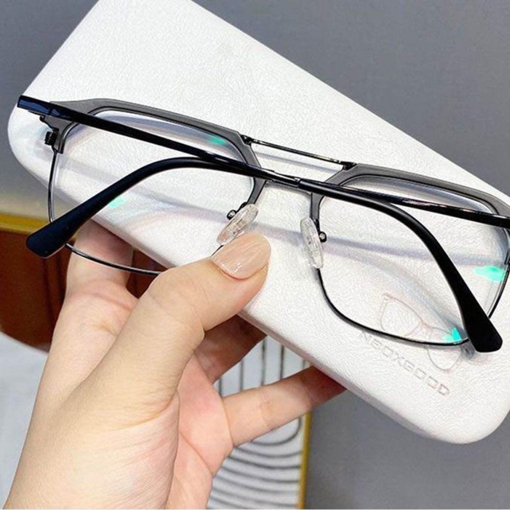Sunglass Lover rectangular metal frame anti-blue light glasses for men held over a white glasses case