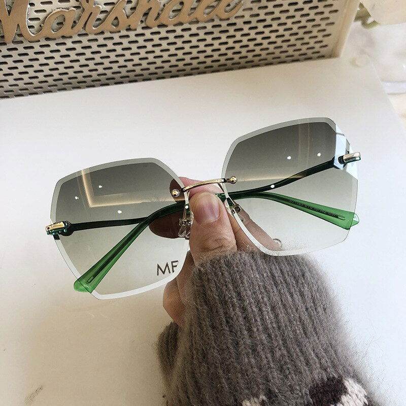 Sunglass Lover oversized rimless sunglasses for women gray gradient lenses green temples held by hand