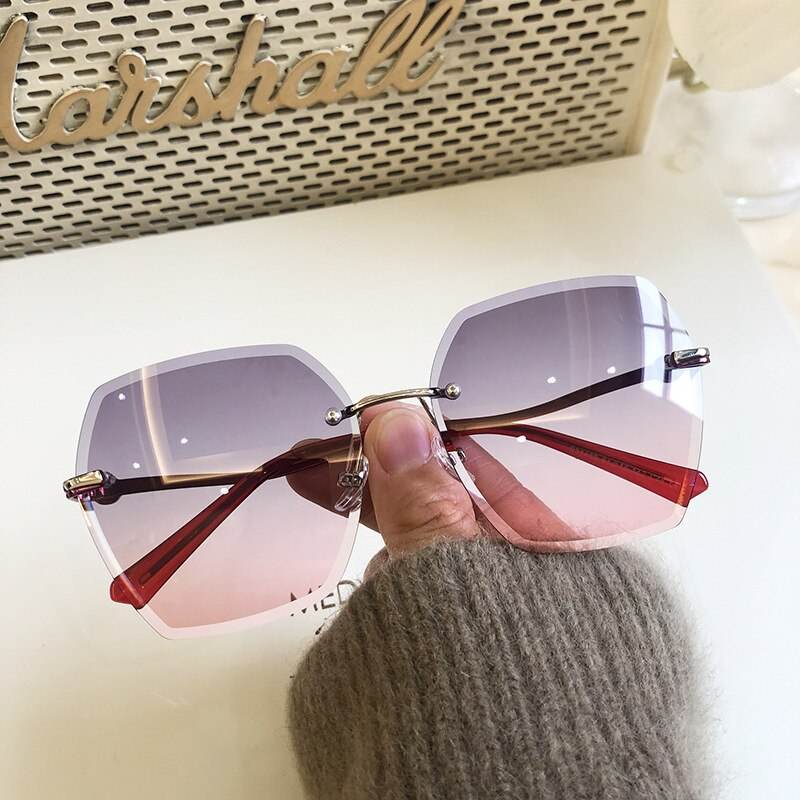 Handheld gradient pink to purple oversized rimless sunglasses for women with silver bridge