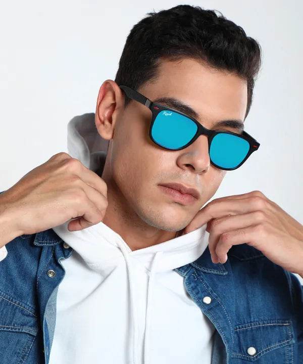 Male model wearing blue wayfarer sunglasses with black frames and mirrored lenses in denim jacket