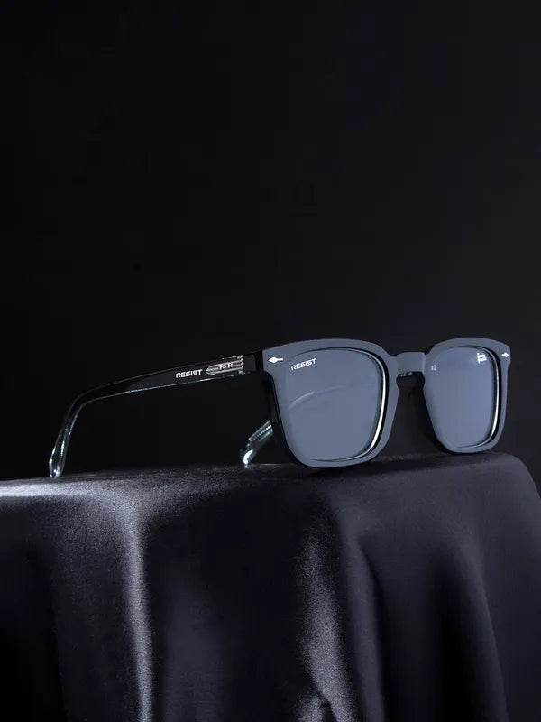 Sunglass Lover Antiblue eyeglasses with clear black eyeglass frames and square lenses resting on black satin surface