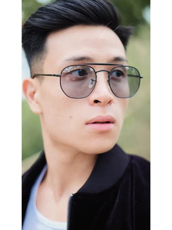 Sunglass Lover photochromic day night glasses aviator metal frame on young man with light gray transition lenses outdoors