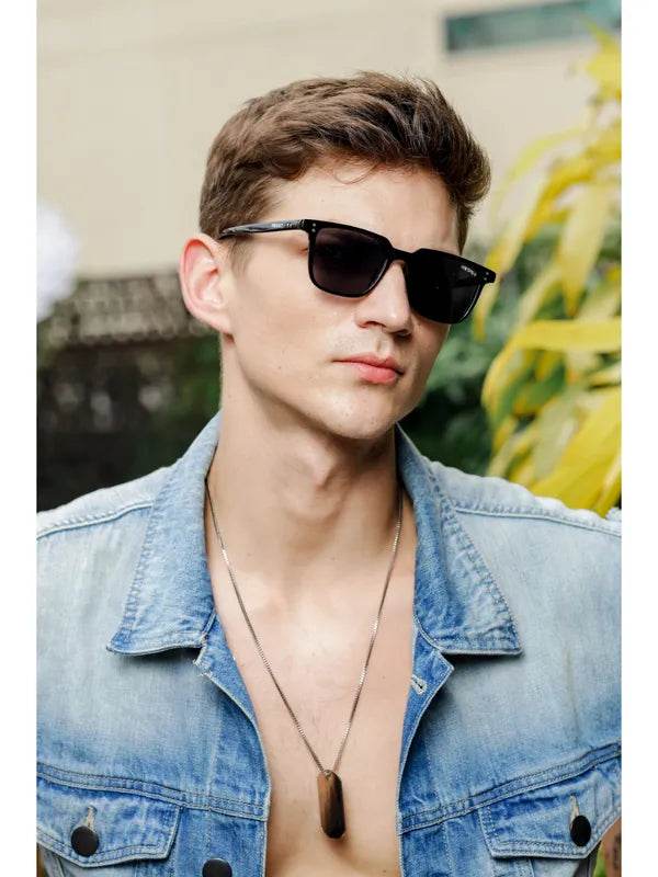 small black rectangle sunglasses on male model wearing denim jacket and pendant necklace outdoor lifestyle