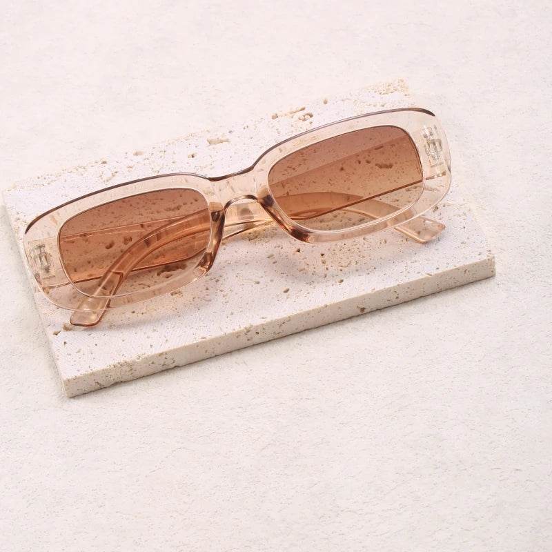 Sunglass Lover Jimmy Rectangle sunglasses transparent peach frame with brown gradient lenses on stone slab