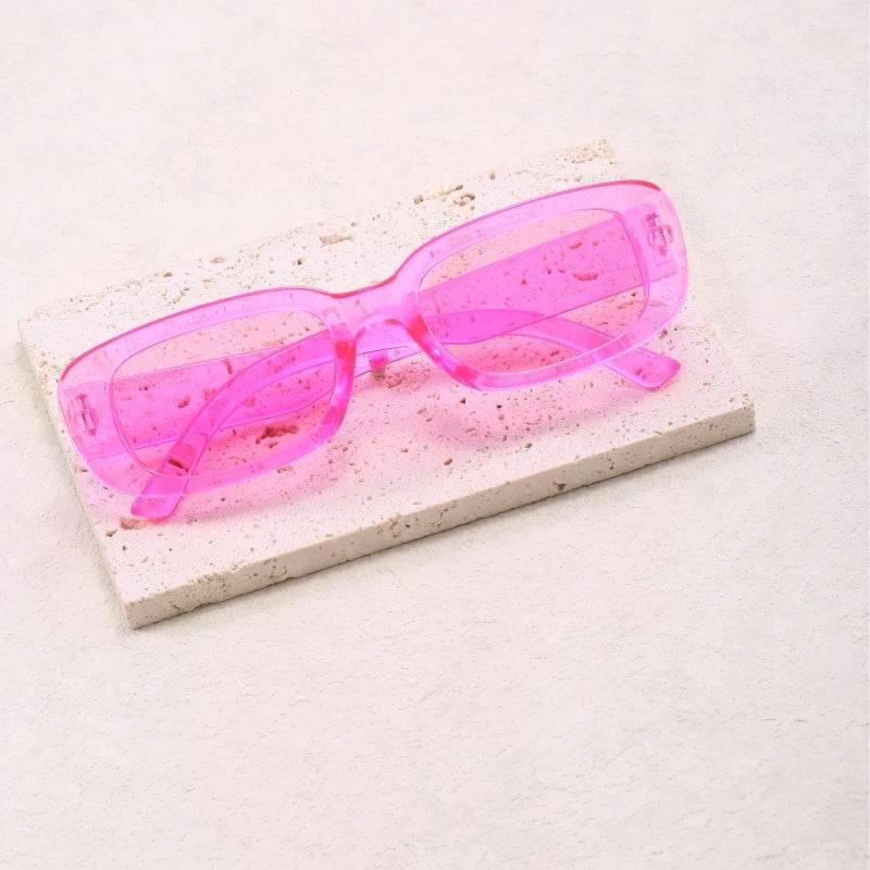Sunglass Lover Jimmy Rectangle sunglasses translucent pink rectangular frame on stone display for fashion accessories