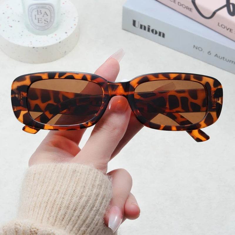 Sunglass Lover Jimmy Rectangle sunglasses tortoiseshell rectangular frame with brown lenses held in hand