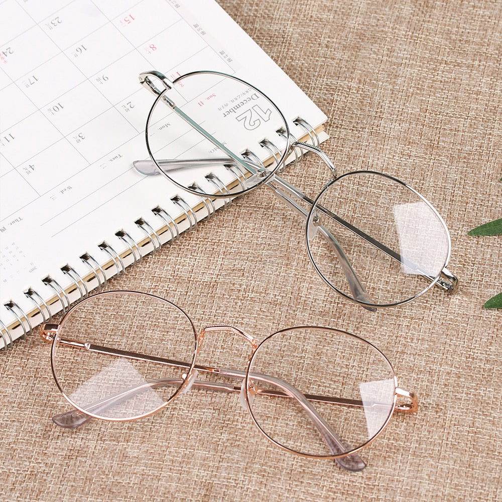 round metal frame reading glasses two pairs silver and rose gold on planner and linen surface