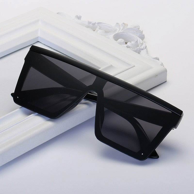 Sunglass Lover vintage black square oversized sunglasses flat top shield frame on white decorative background