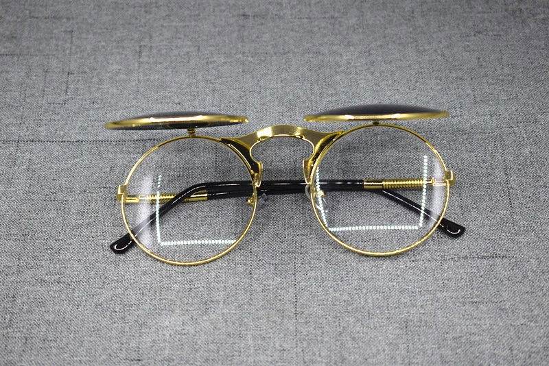 Sunglass Lover gold round metal frame flip up sunglasses with clear lenses and black temple tips on gray fabric