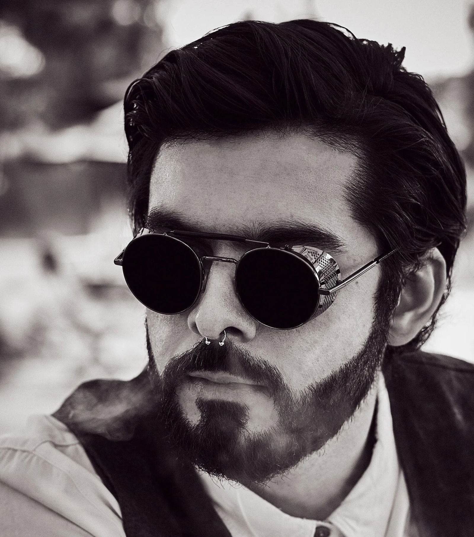 Sunglass Lover model wearing retro vintage round sunglasses with black metal frame beard and septum piercing
