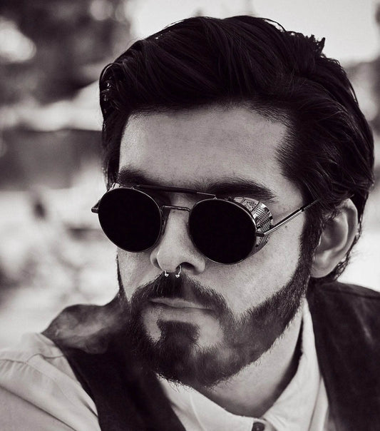 Sunglass Lover model wearing retro vintage round sunglasses with black metal frame beard and septum piercing