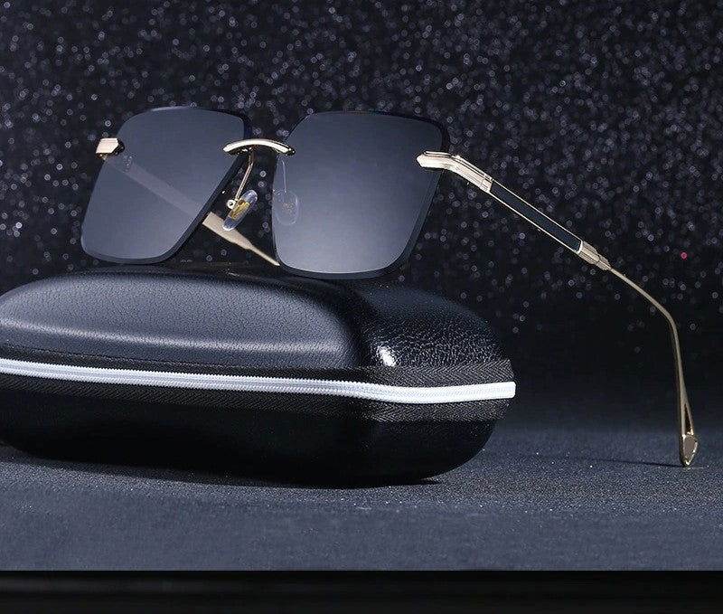 Sunglass Lover oversize square rimless sunglasses with gold temples and dark gradient lenses on black zippered case