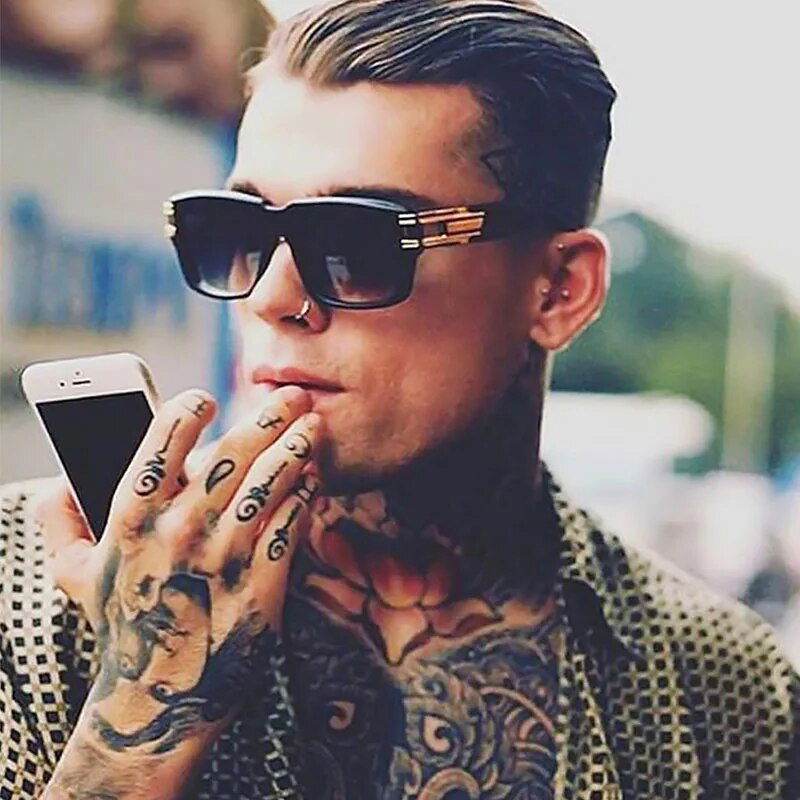 Stylish tattooed man wearing Sunglass Lover unisex square sunglasses holding smartphone with slicked back hair