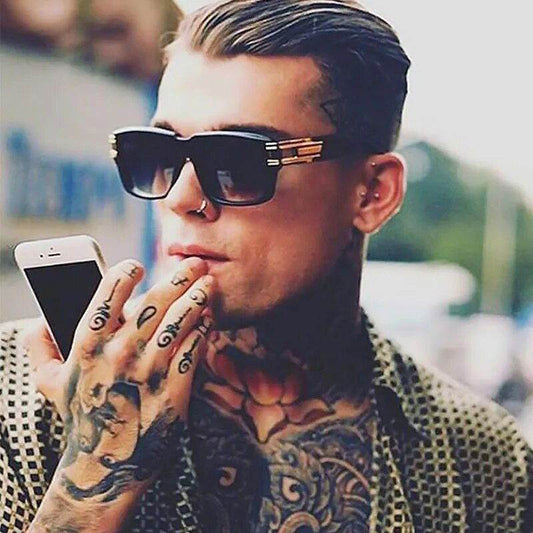 Stylish tattooed man wearing Sunglass Lover unisex square sunglasses holding smartphone with slicked back hair