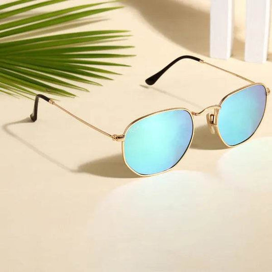 Sunglass Lover hexagonal blue reflector sunglasses gold metal frame black temple tips on sandy surface