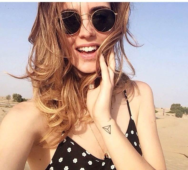 Sunglass Lover round sunglasses for men and women worn by smiling woman in desert with gold frames