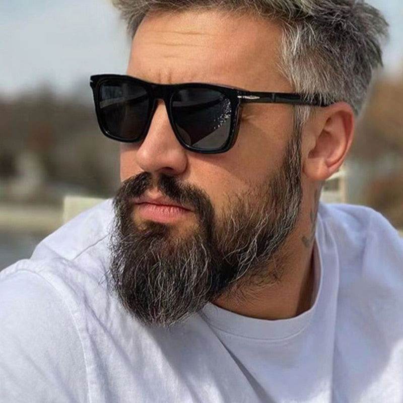 Sunglass Lover black square sunglasses for men and women modeled by bearded man outdoors