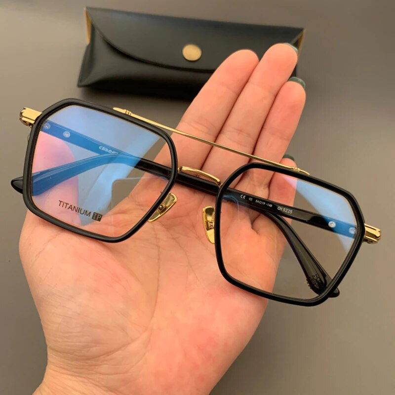 Sunglass Lover unisex hexagonal eyeglasses black and gold titanium frame with blue tinted lenses held in hand
