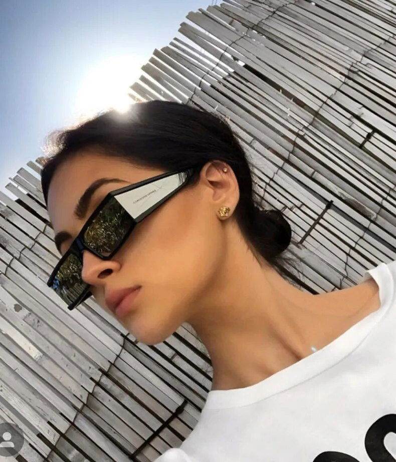 Sunglass Lover model wearing black retro rectangle sunglasses for women with mirrored side panels and gold stud earrings