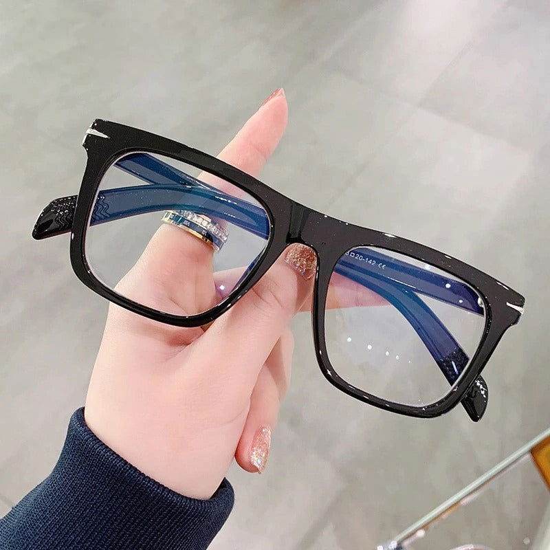 Sunglass Lover black frame blue light blocking square glasses held in hand showing blue reflective lenses