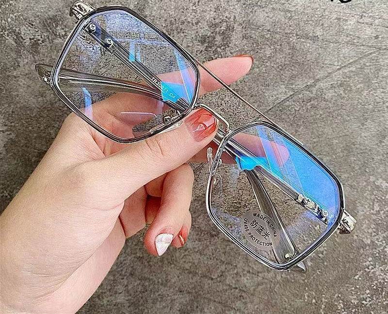 Sunglass Lover silver metal rectangular frames held in hand showing blue reflection punk style blue light blocking eyeglasses