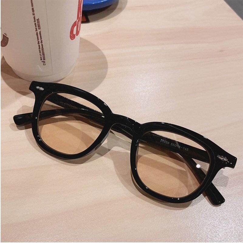 Sunglass Lover black acetate vintage round sunglasses for men and women with brown tint on table near coffee cup