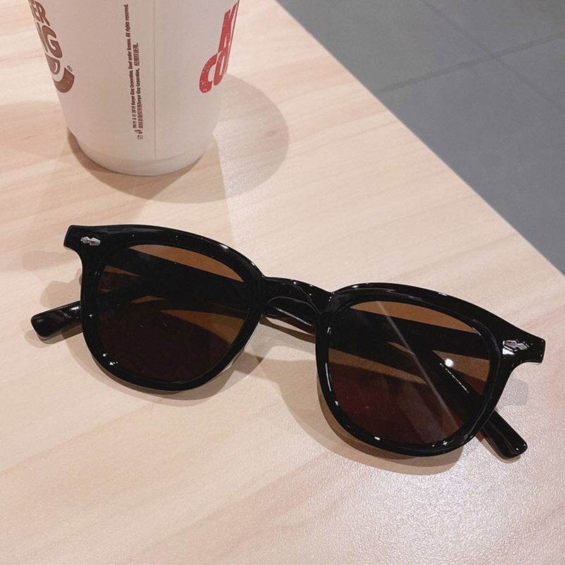 Sunglass Lover black frame with brown lenses on wood table vintage round sunglasses for men and women