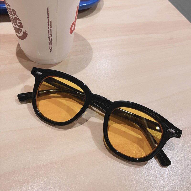 Sunglass Lover black acetate sunglasses with amber lenses on a table vintage round sunglasses for men and women.