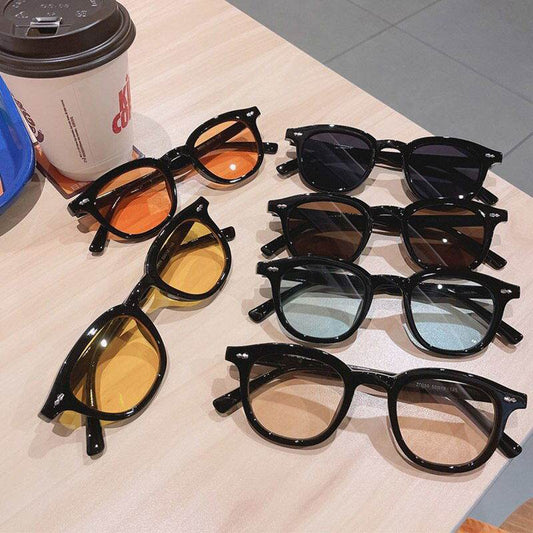 Sunglass Lover display of black framed colored lens vintage round sunglasses for men and women.