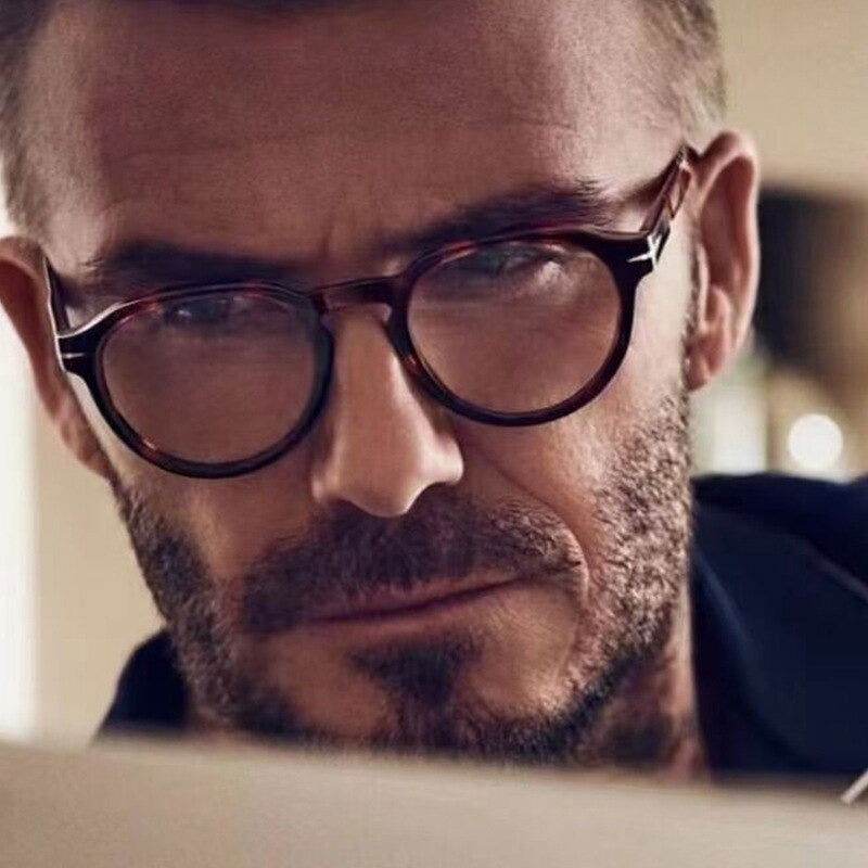 Sunglass Lover tortoiseshell round frames blue light blocking eyeglasses for men worn by bearded man reading
